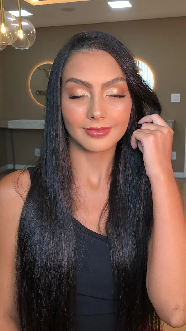 Cliente com maquiagem iluminada em tons dourados no Studio